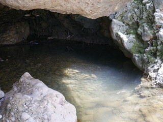Crystal clear water in a cave in the mountain, bathed in sunlight