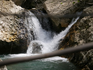 River flowing between rocks, forming a small waterfall in the mountains of Ronda, Spain, with...