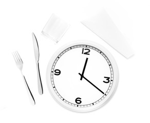 Fork, knife, glass, napkin and white round clock