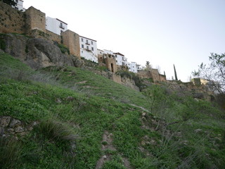 Fototapeta na wymiar View of old houses up a hill in Ronda, Spain