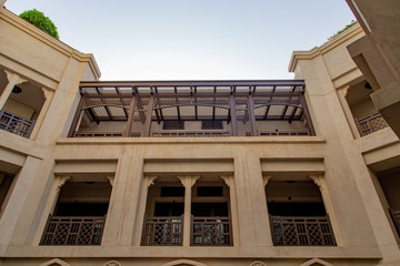 Fototapeta na wymiar Traditional arabic building in old town at Dubai downtown. Arabic architecture. Townouse villa in office district. Arabic pattern on balcony and windows. Luxury housing and office space in UAE.