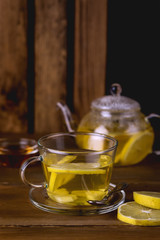 Glass Cup and Glass Teapot with Hot and Tasty Lemon and Ginger Tea Hot Autum Winter Drink Vertical Toned