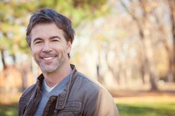 men, coat, human teeth, 50-59 years, portrait, real people, confidence, smiling, mature men, casual clothing, green color, glamour, elegance, modern, lifestyles, outdoors, looking at camera, close-up