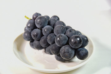 白い皿に乗った巨峰