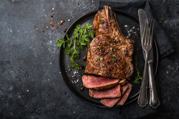 Fototapeta sliced beef steak on black plate obraz