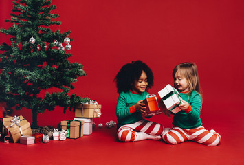 Kids exchanging christmas gifts