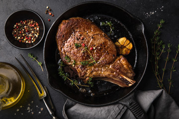 beef steak on cast iron pan, dark background