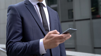 Businessman scrolling smartphone using financial app for monitoring stock market