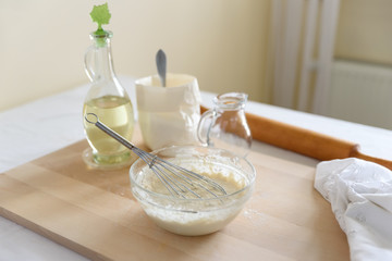 Cooking pizza. Mixing ingredients for pizza or bread. Woman hands preparing dough. Selective focus. Back view