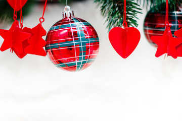 Shiny red christmas balls, heart and stars on white with pine tree for new year