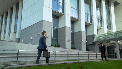 Depressed employee leaving business center, European walking inside