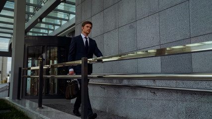Ambitious businessman leaving office center after successful meeting, routine