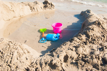 Fototapeta na wymiar Scoop bucket and watering can on the shoreline