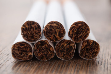closeup of cigarettes pile on wooden table background