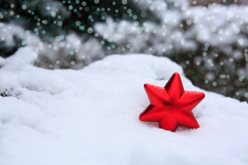 Red Christmas star on white snow. Winter background.