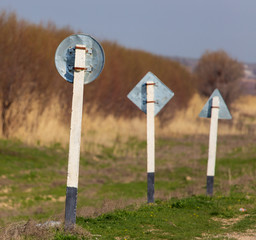 Metal road sign stands near the road