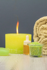 Fototapeta na wymiar Spa composition with towel, sea salt, aromatic oil, soap and candle.
