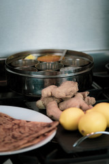 A round container for spices - with ginger and roti - cooking Indian food. 