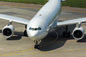Modern passenger civil airplane taxiing at international airport
