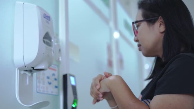 Woman washing hand by alcohol before visiting patient in hospital