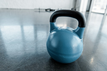 Obraz na płótnie Canvas large blue kettlebell on gym floor with copy space