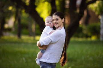 Fototapeta premium Mom holds a small son in the hands of nature. Walk with the child.