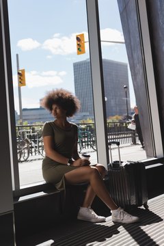 Woman With Luggage Bag Sitting At Airport