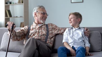 Fototapeta premium Grandson and grandpa laughing, joking, having good time together, communication