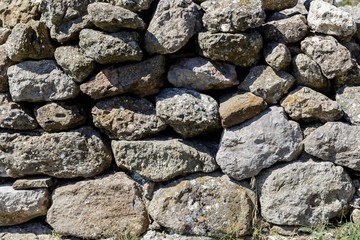 The wall of the ancient fortress is made of stones. Texture.