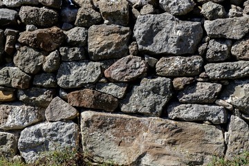 The wall of the ancient fortress is made of stones. Texture.