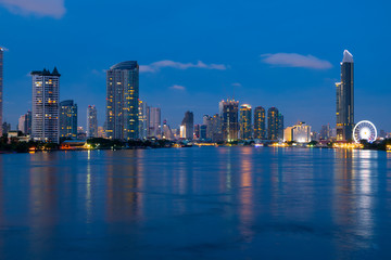 Fototapeta na wymiar Bangkok city skyline with Chao Phraya river at night during blue hour and famous travel place landmark.