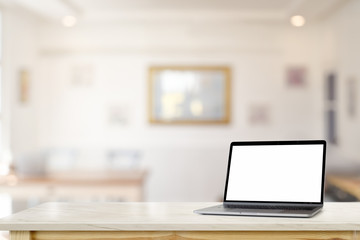 Mockup blank screen laptop on marble desk table over living room.