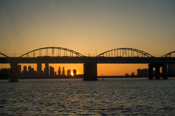 Fototapeta na wymiar a calm river and an arch bridge and sunset