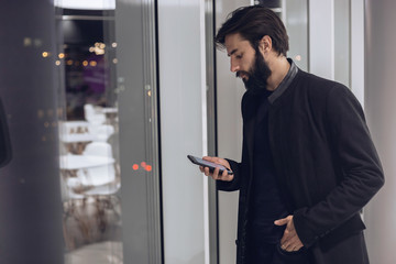 Modern man looking at his smartphone