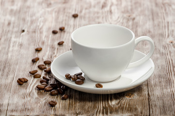 Coffee cup and coffee beans on vintage wooden background