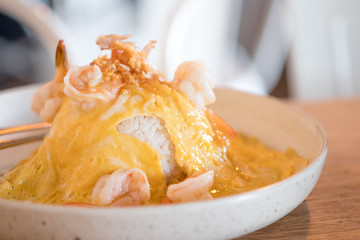 Scrambled eggs served with shrimp on rice