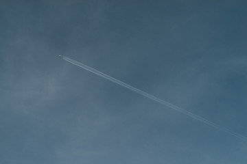 Contrails of aircraft over blue sky while flying above Kuala Lumpur, Malaysia.