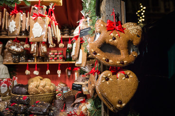Showcase of the European Christmas market with gingerbread presents, a variety of pastries and Christmas decor in the evening