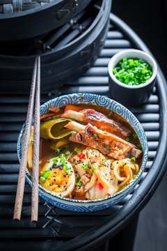 Delicious Kimchi soup with chive and noodles on black table