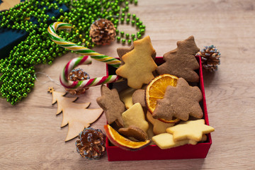 Tasty Homemade Christmas Cookies in Red Box with Festive Decoration on a Wooden Background.