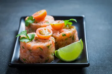 Rollo Closeup of salmon tartare with lime and cherry tomatoes © shaiith