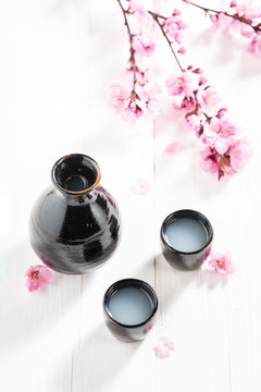 Sake in old black ceramics on white table