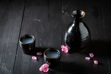 Sake in black ceramics on dark table © shaiith
