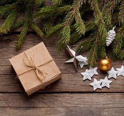 Christmas tree with gift box and decorations on wooden background