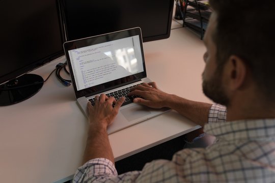 Business executive using laptop at desk