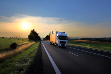 Obraz na płótnie Canvas Truck transport on the road at sunset