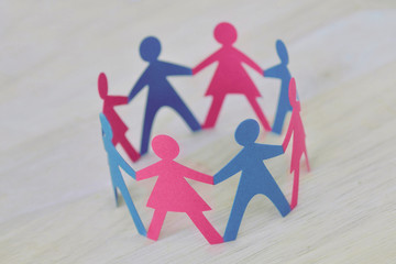 Paper men and women cut-out in a circle holding hands - Gender relationship concept
