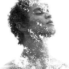 Double exposure in black and white of a young sexy man’s portrait blended with branches of a...
