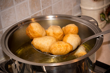 Dipper taking off Dough from a Pot after Friying during the Preparation of an Italian Christmas Traditional Dish called Pettole