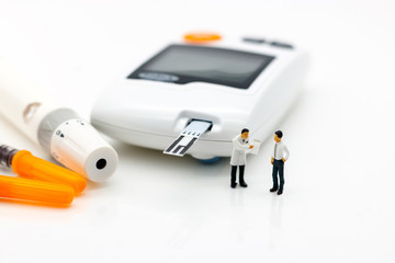 Miniature people: Doctors standing with glucose meter of diabetes  and injection needle , business and health care concept.